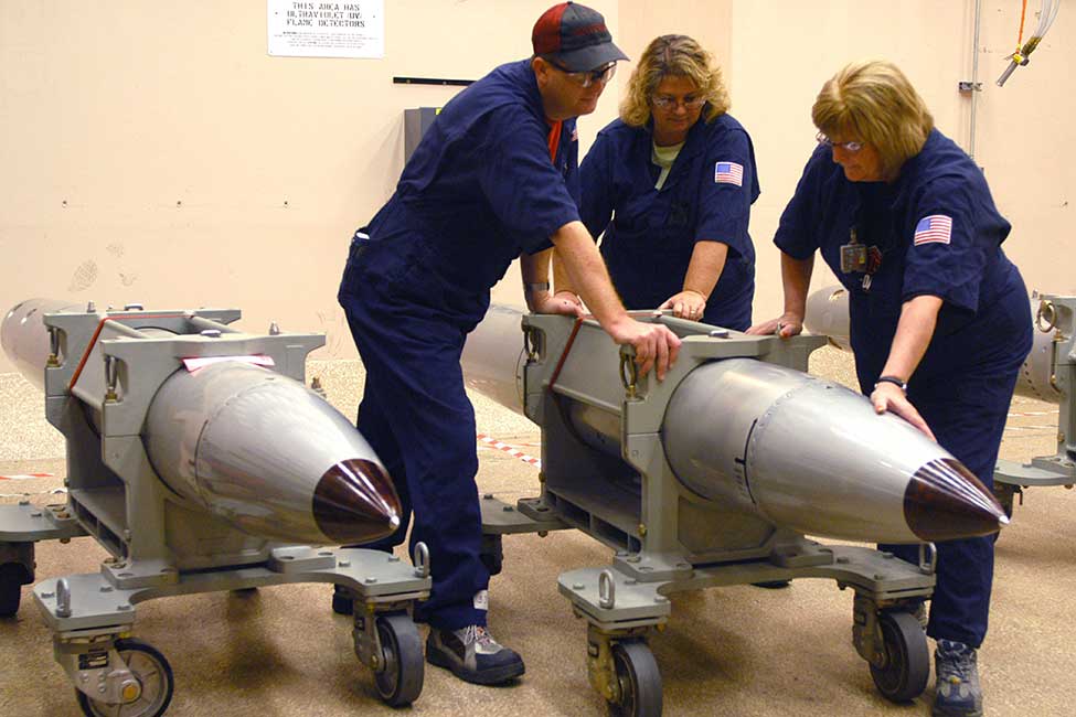 three workers handle a large gravity bomb