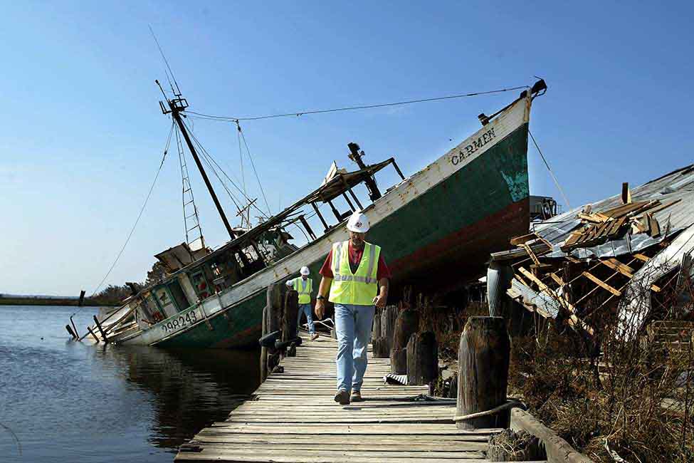 Bechtel personnel survey the wreckage at a dock
