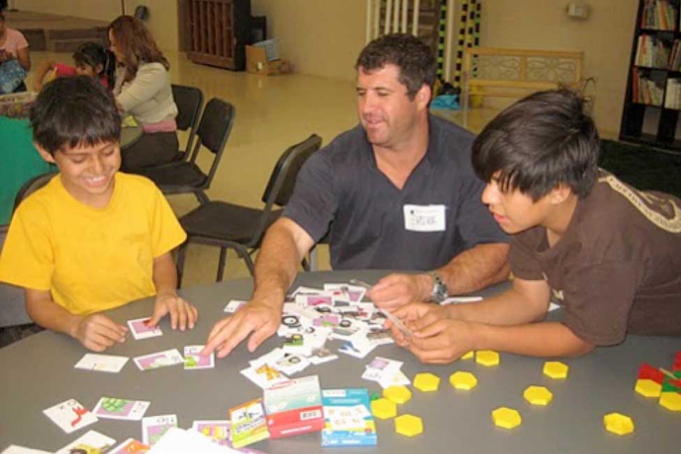 a Bechtel employee helps two young boys complete a puzzle