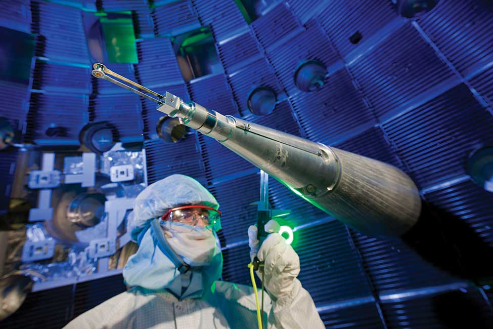 scientist works on an instrument in a clean facility