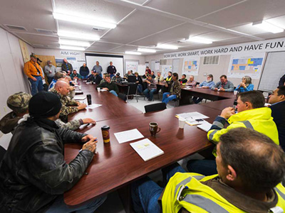 a safety meeting for workers in a trailer