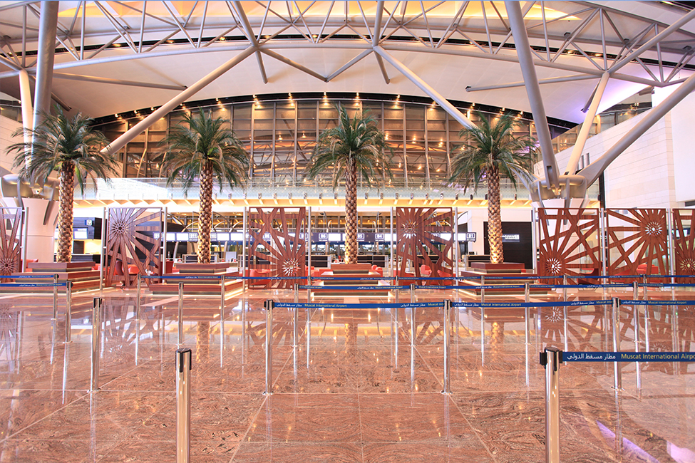 Completed airport terminal building with 3 large palm trees. 