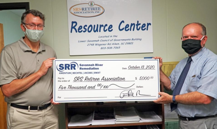 Two men hold a large check made out to SRS Retiree Association