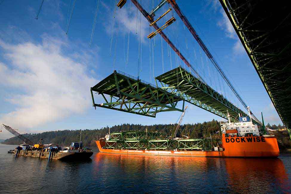 Two gantry cranes were used to hoist the bridge’s 46 steel road deck segments from a barge and install them