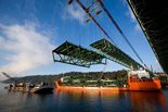 Two gantry cranes were used to hoist the bridge’s 46 steel road deck segments from a barge and install them