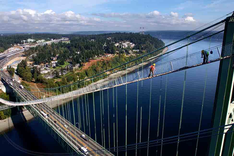 A worker heads to the anchorage structures via the bridge’s catwalk 
