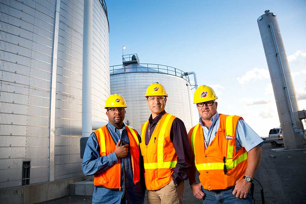 Team members in front of the plant’s fire service water tanks