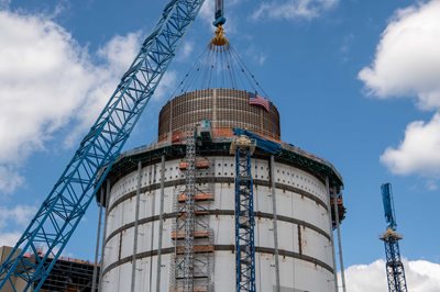 The 720,000-pound passive cooling water tank is placed atop the shield building for Plant Vogtle Unit 4. It is the last major lift for the plant expansion project.