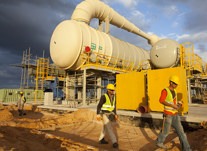two workers walk by a desalination facility