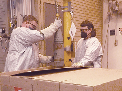 Handlers prepare mustard-agent projectile for SDC at Kentucky BGCAPP plant.