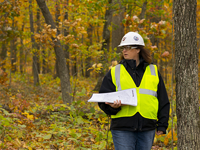 Woman in protective equipment standing in forest