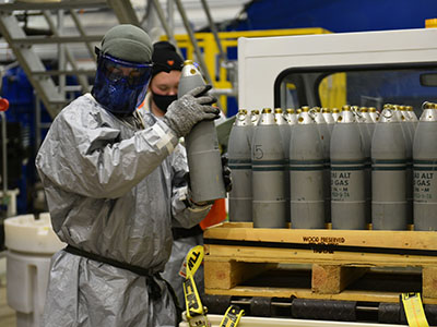 A Pueblo Chemical Agent-Destruction Pilot Plant ordnance technician holds the first 4.2-inch mortar round to be processed in the Static Detonation Chamber.