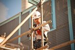 A craft worker installs scaffolding