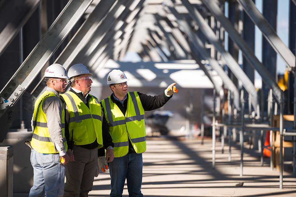 Workers review the project’s progress