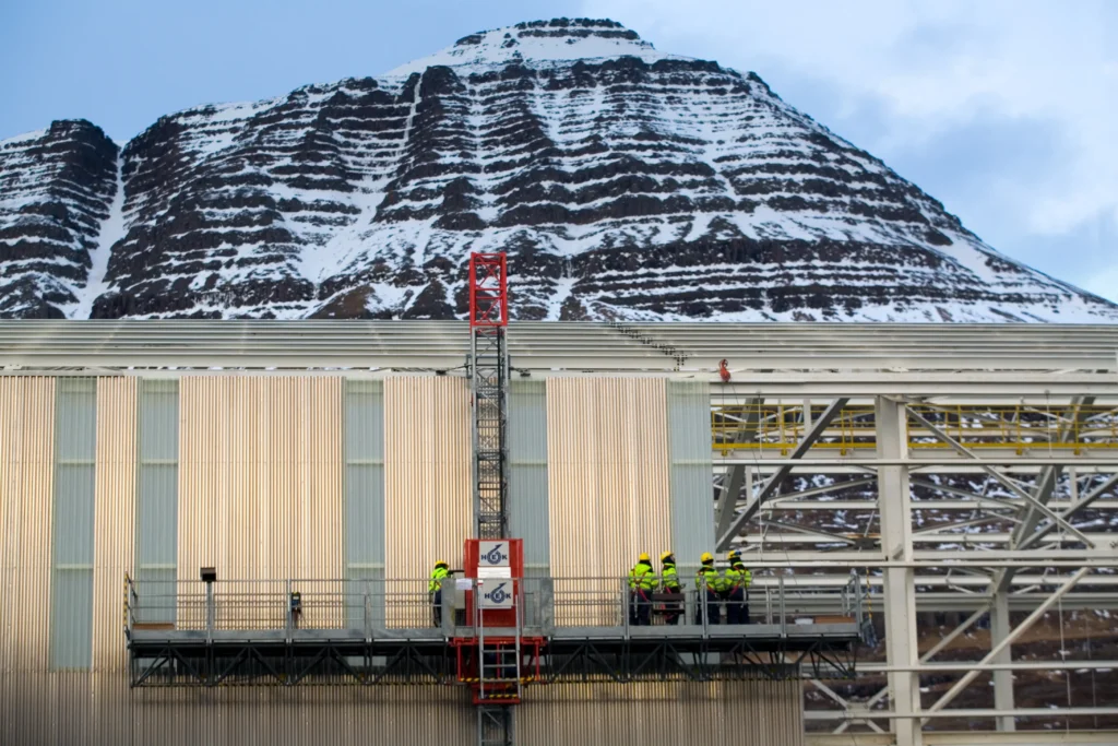 Fjarðaál Aluminum Smelter Workers with mountain