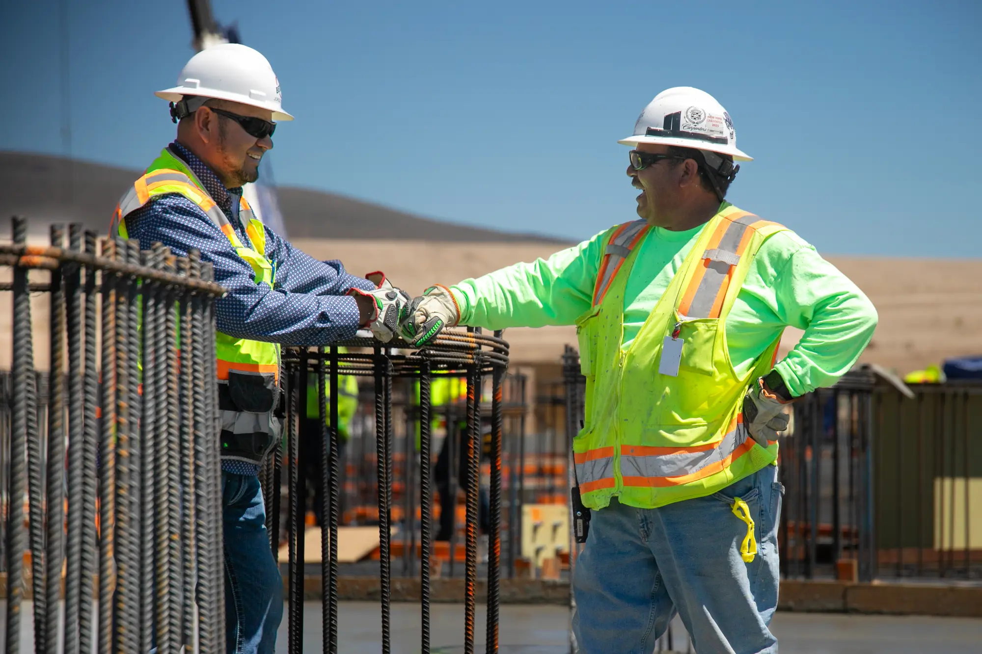 Two men chatting at a outdoor jobsite. 