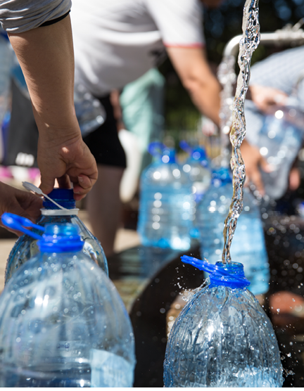 Collecting natural spring water with 5 litre plastic water bottle at Newlands natural spring Cape Town South Africa 